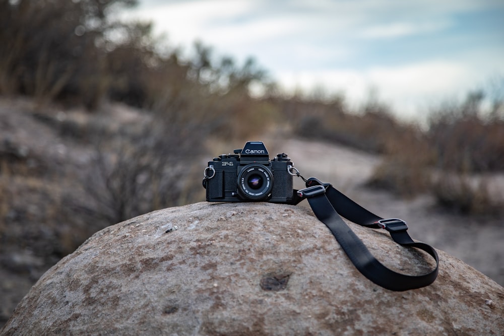 fotocamera DSLR nera su roccia