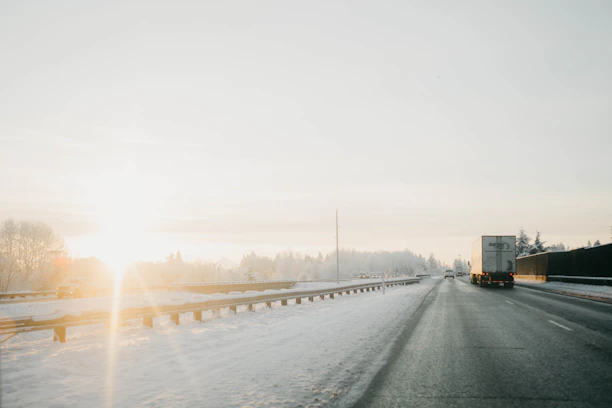 A NordLynx truck driving along a scenic Canadian highway at sunrise.