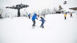 people playing snowboard at snow