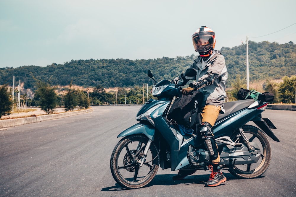 man riding on green underbone motorcycle