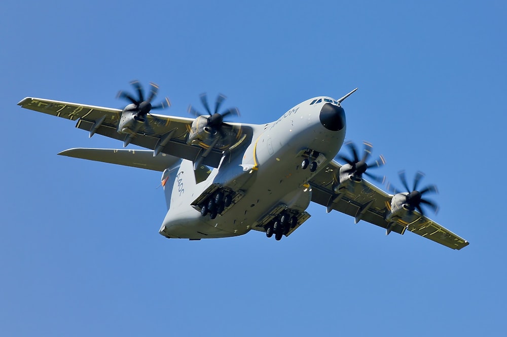Avião de carga militar cinzento em voo sob céu azul claro