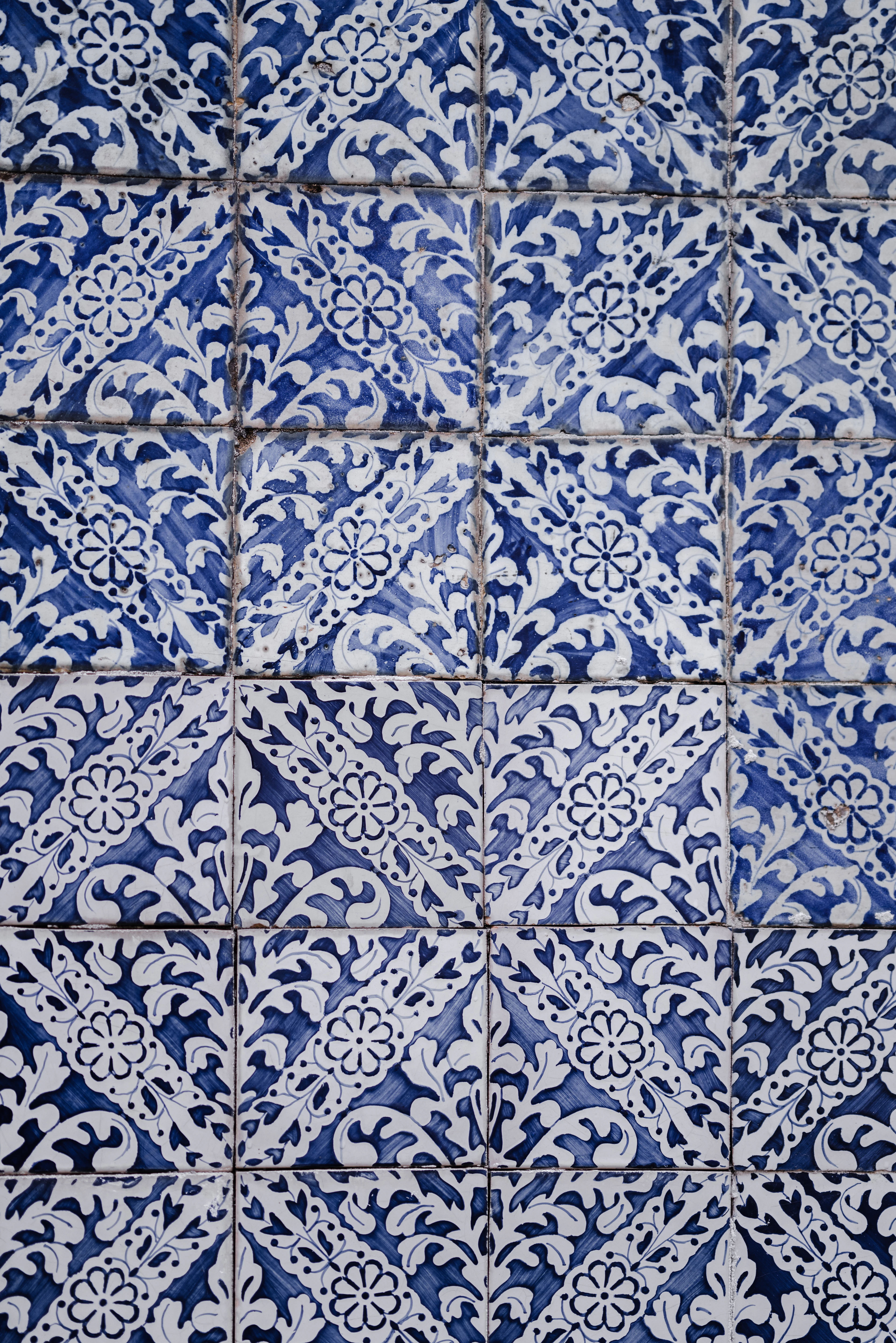 Patterned blue and white wall tiles with grout lines