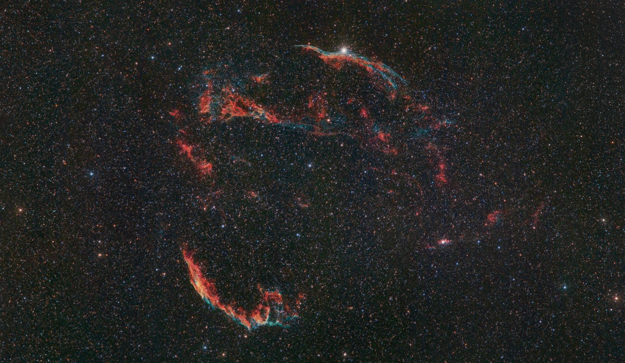 The Veil nebula, remnant of a dying star and still an astronomical mystery. This emission nebula of ionized gas is very large in size, both visually in our sky and physically in space. 6 full Moons wide and 90 light years in size, 5 to 10 thousand years old and 1500 lights years away. There is no neutron star at the center of this nebula, there is one neutron star at the base of the blowout region but of unknown distance. The intertwined rope-like filaments of oxygen, sulfur and hydrogen gas are all that remains visible of what was once  a star in our Milky way galaxy.