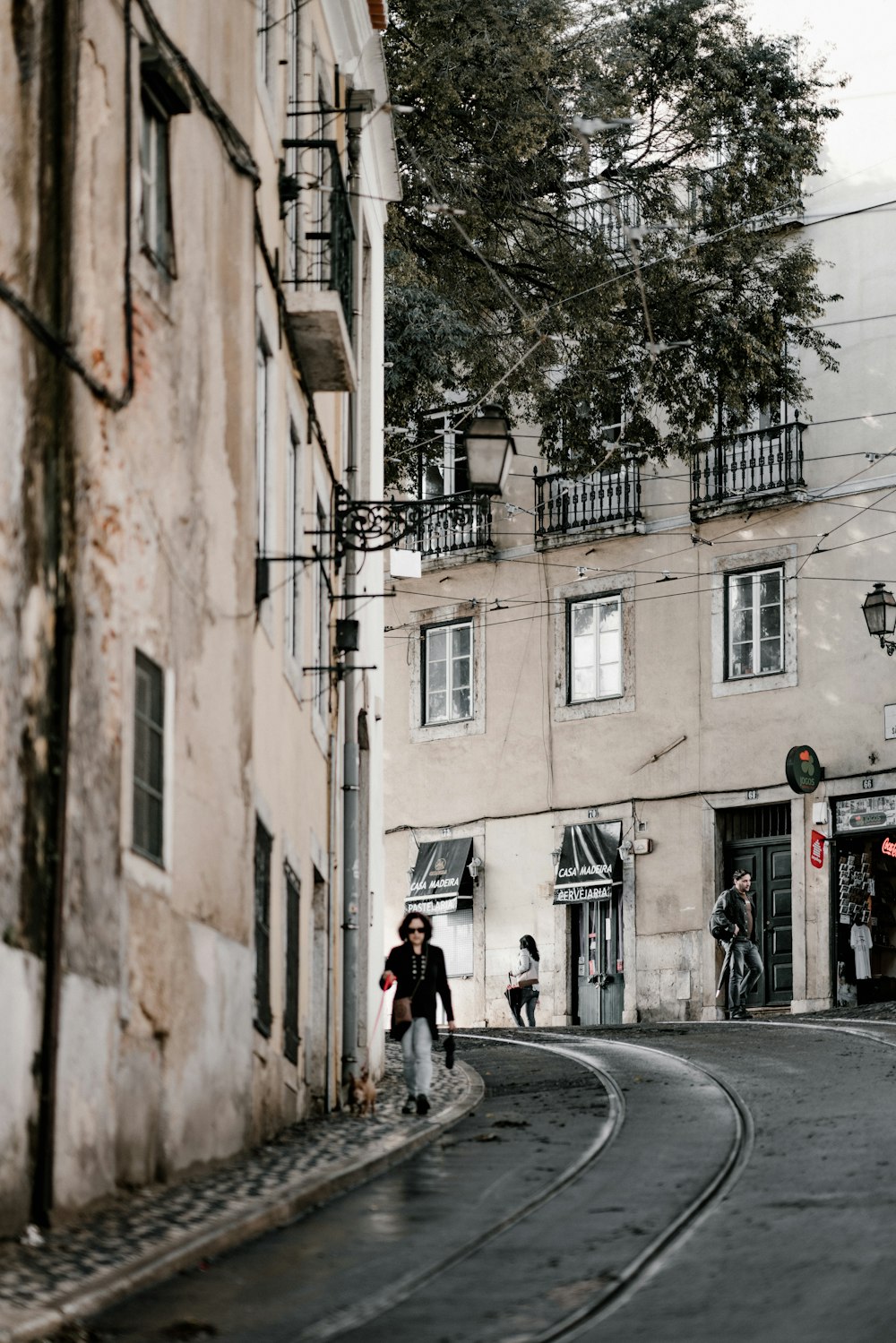 Hombre caminando cerca de edificios de hormigón blanco