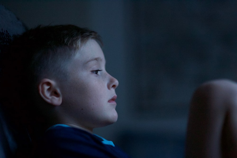 boy leaning on black wall