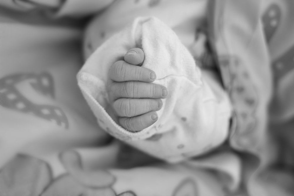grayscale photo of baby's hand
