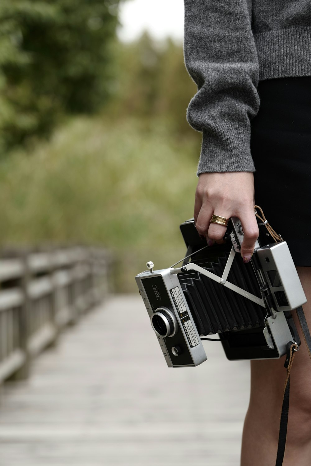 person standing and holding black and gray land camera