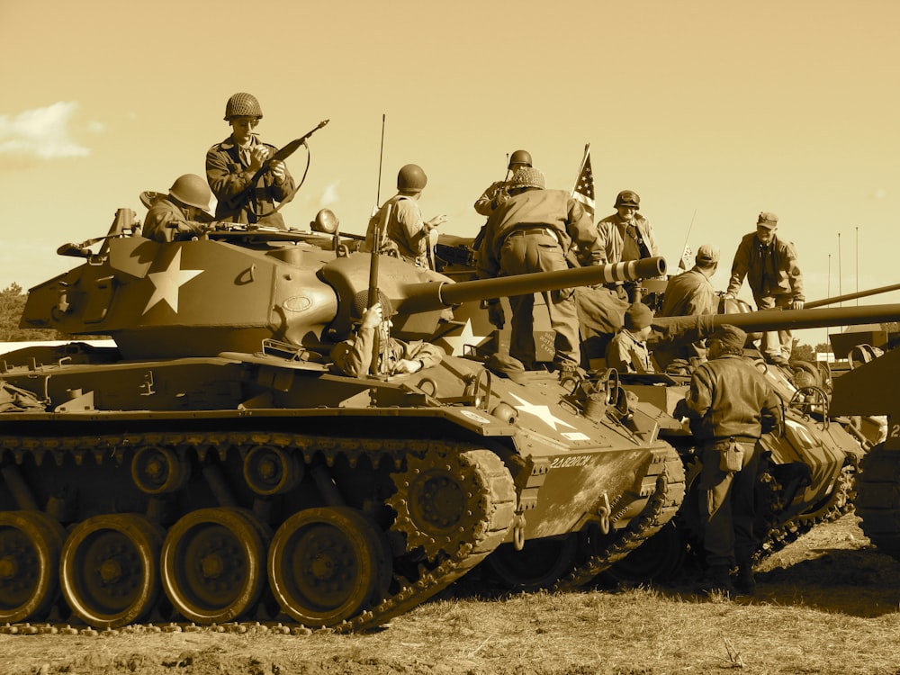 전투 탱크에 앉아서 서 있는 사람들