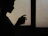 A cozy scene of a hand holding a brightly colored šiluma mug beside a softly lit window.