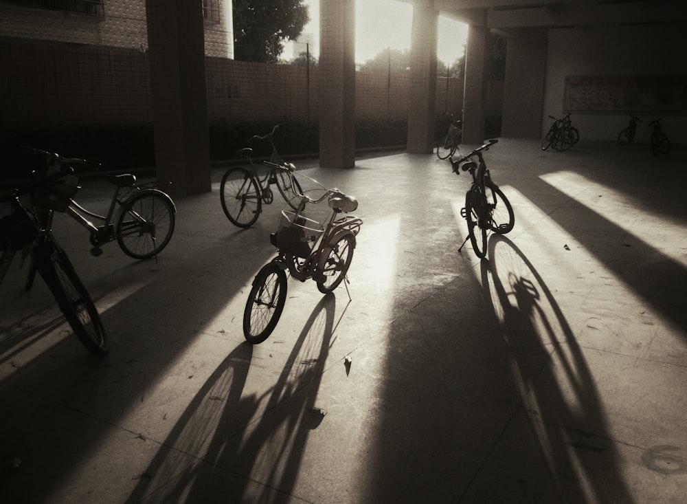 four black bikes near post during daytime