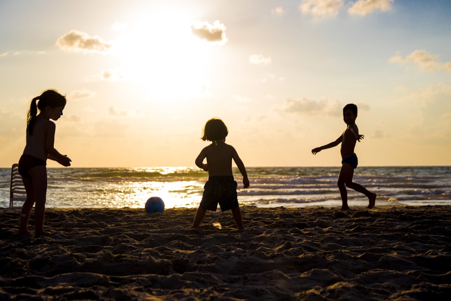 Silhouette of children playing on the beach at sunset