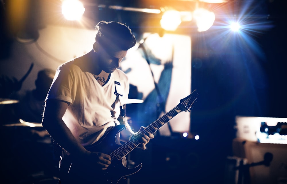 standing man playing electric guitar