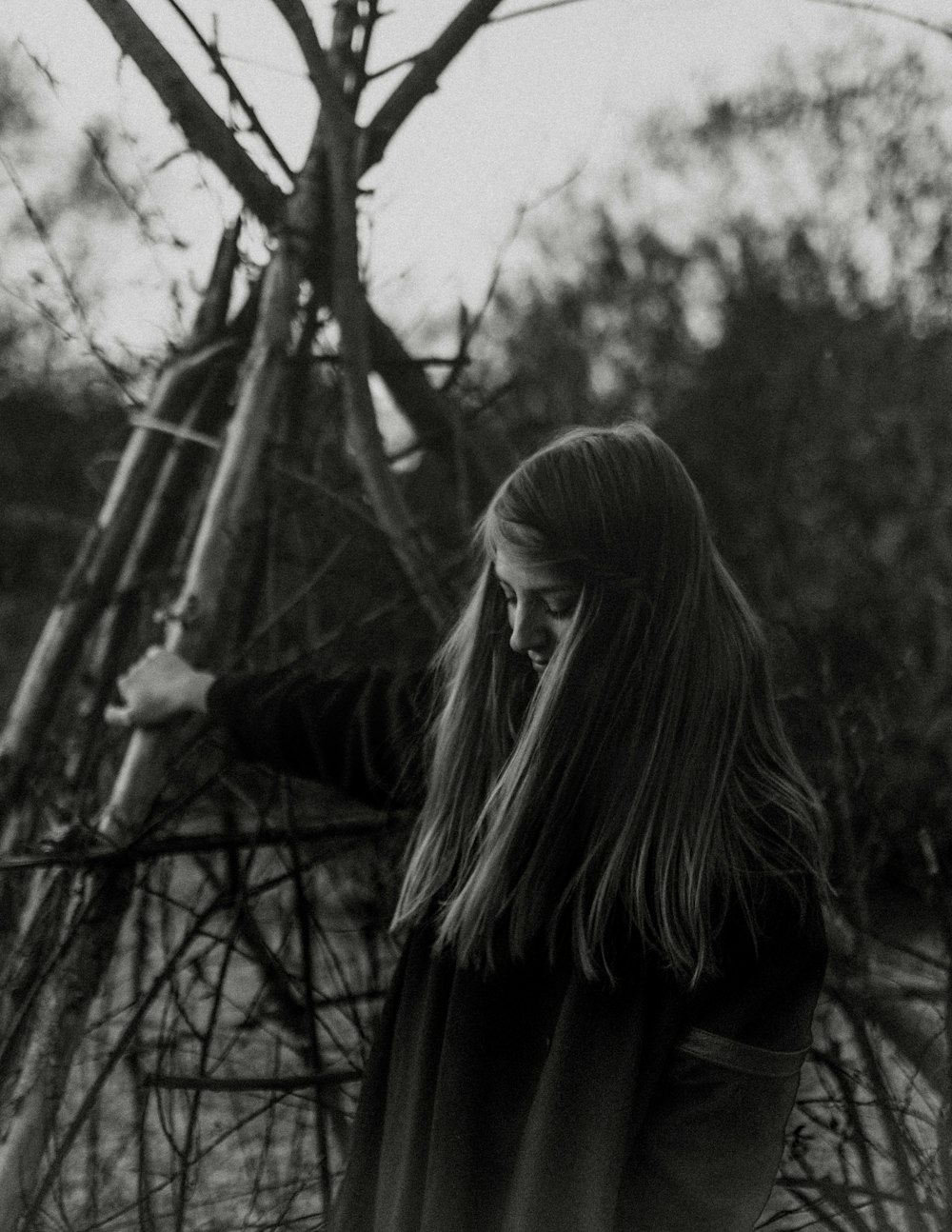 grayscale photography of woman wearing wooden post