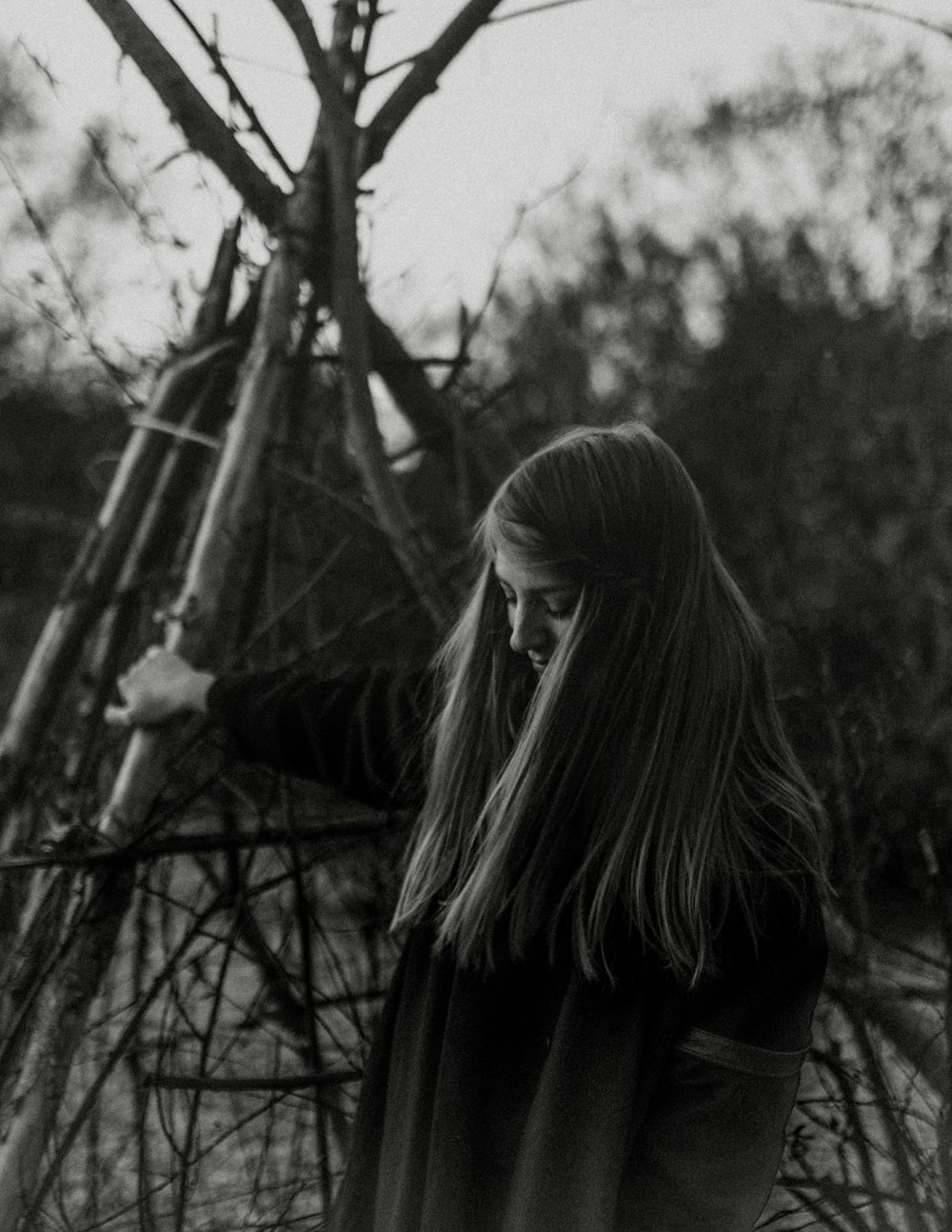 Fotografía en escala de grises de mujer con poste de madera