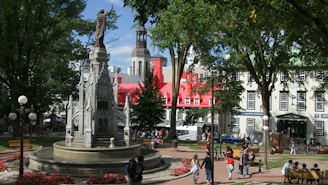 Statue of Sofía Vergara in a lively urban park with palm trees and visitors nearby