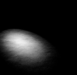 a black and white photo of a light in the dark