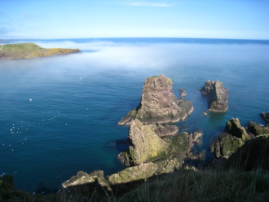 rock on body of water during daytime in Dunnottar Castle United Kingdom