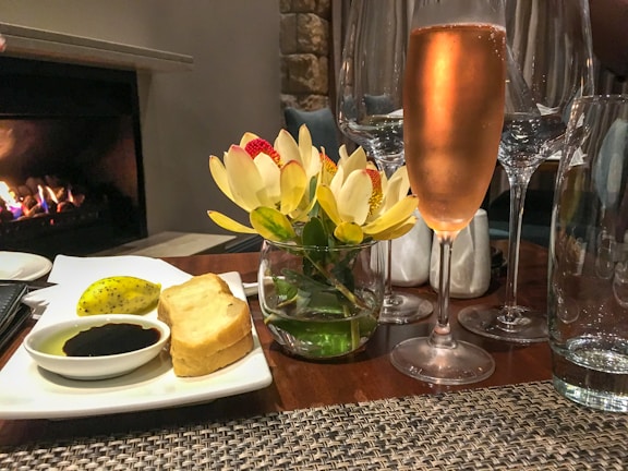 Cozy bistro table setting with a glass of red wine and a rustic bread basket.