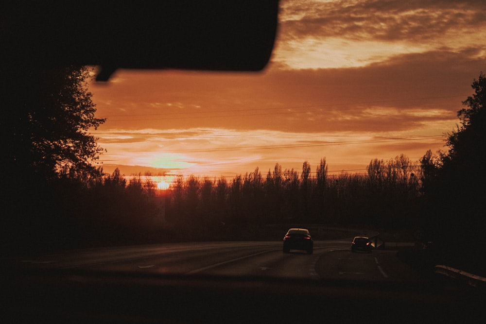 vehicles crossing road during golden hour