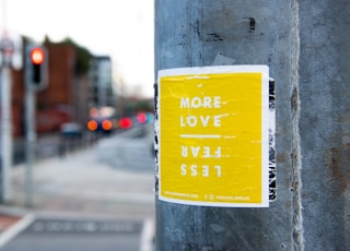 more love less fear sticker on post