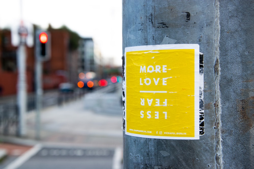 more love less fear sticker on post