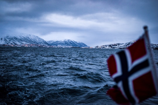 red, white, and black cross graphic waving flag in Tromsø Norway