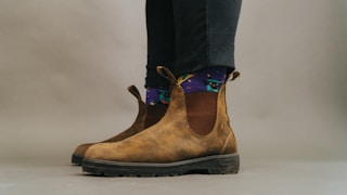 person wearing brown and black boots