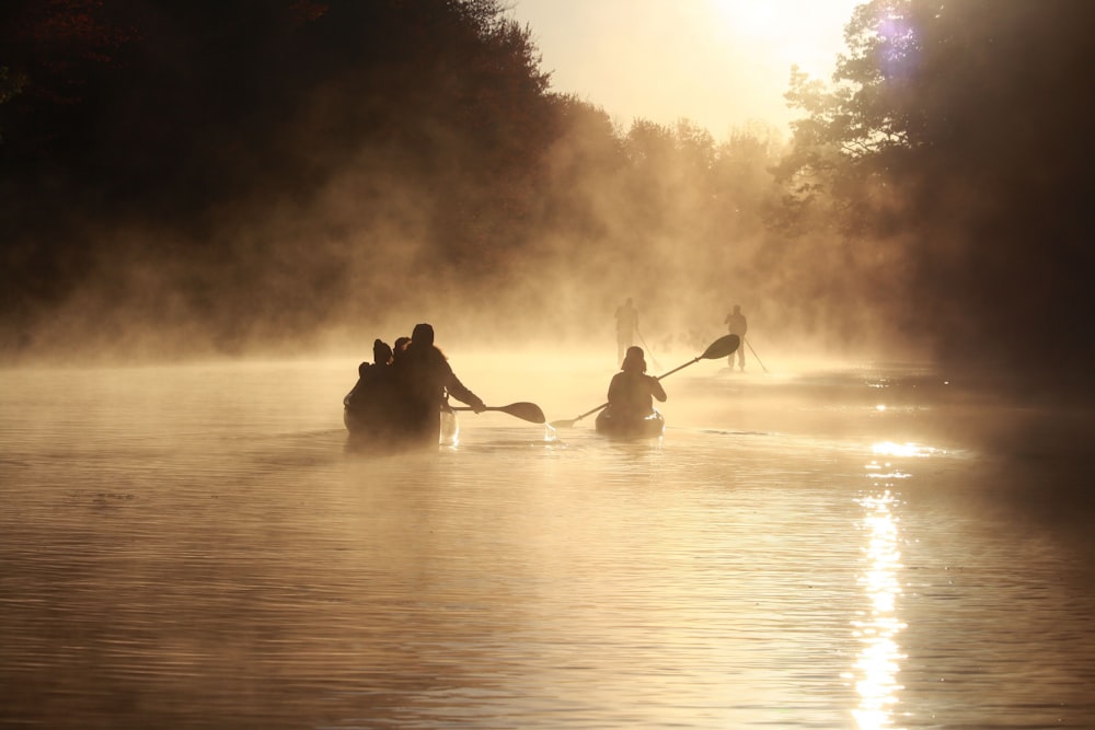 a group of people paddling on canoes on a lake