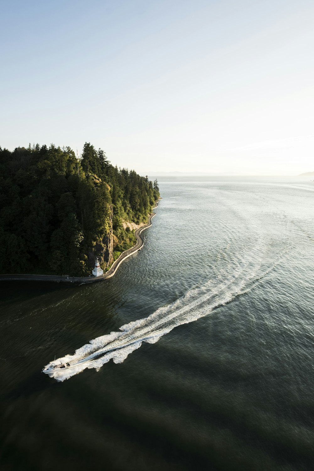 Weißes Schnellboot, das tagsüber unter strahlend blauem Himmel auf dem Meer vorbeifährt