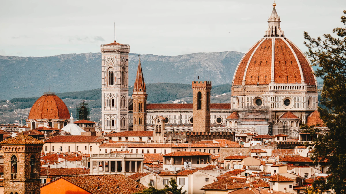 Florence skyline at sunset with the Duomo cathedral dome and Giotto's bell tower rising above terracotta rooftops