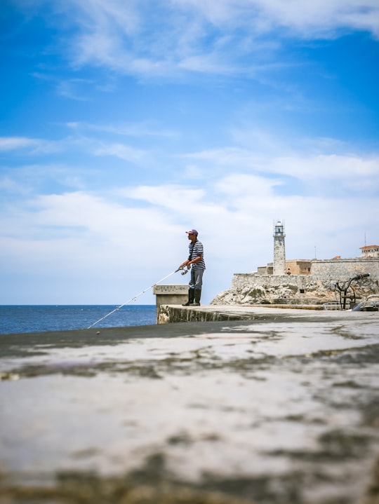 man standing on cliff in Castillo de San Salvador de la Punta Cuba