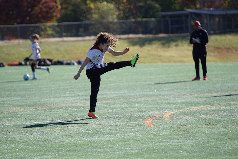 girl kicking in air near girl and man holding white paper