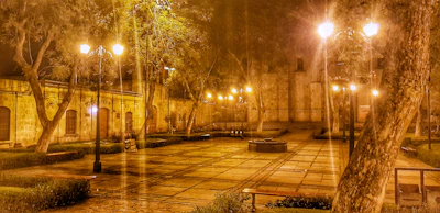 Evening scene of Plaza Caguán with warm lights and people enjoying the ambiance.