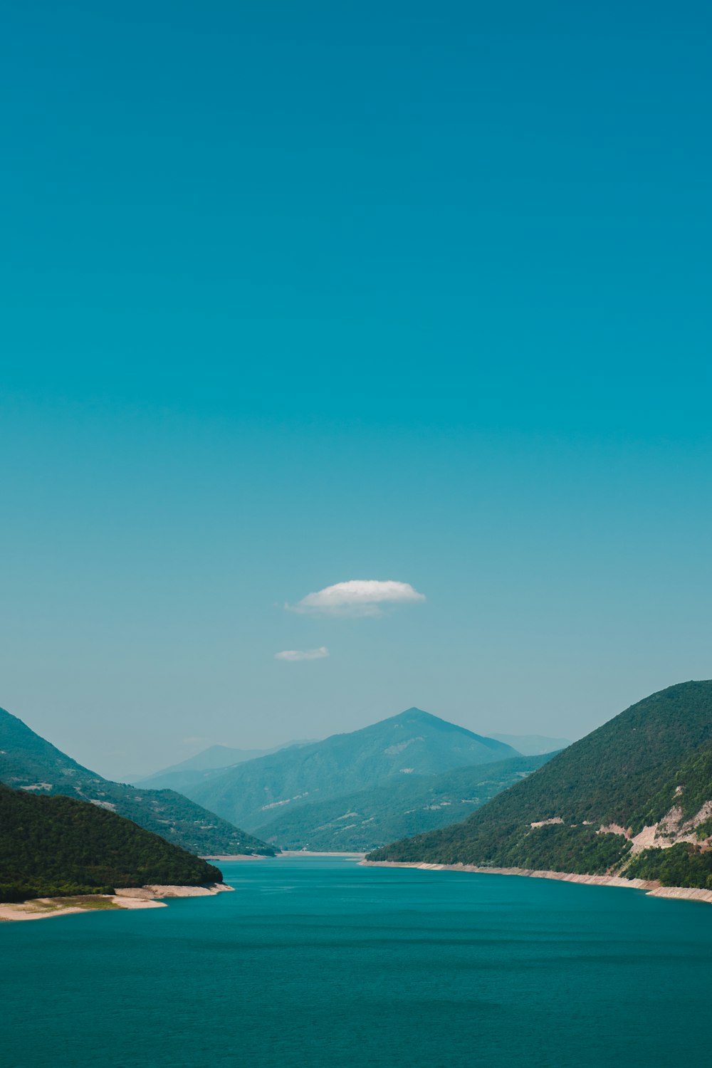 lake and mountains under blue sky