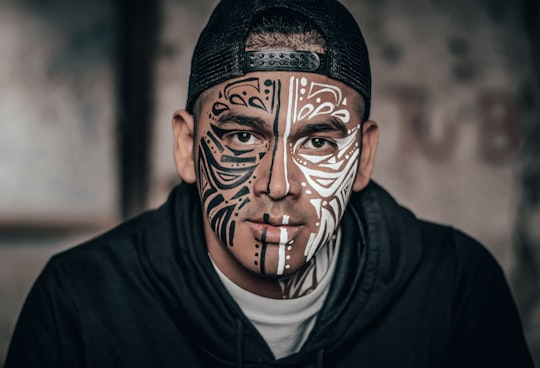 man with black and white face tattoo in Lima Peru
