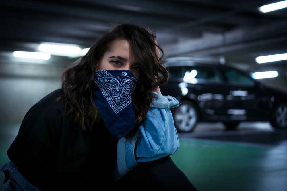 woman sitting on parking area pavement