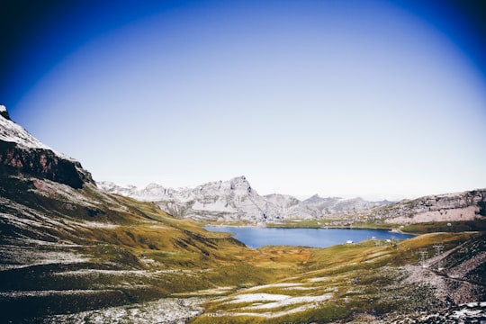 mountains near body of water during daytime in Melchsee-Frutt Switzerland