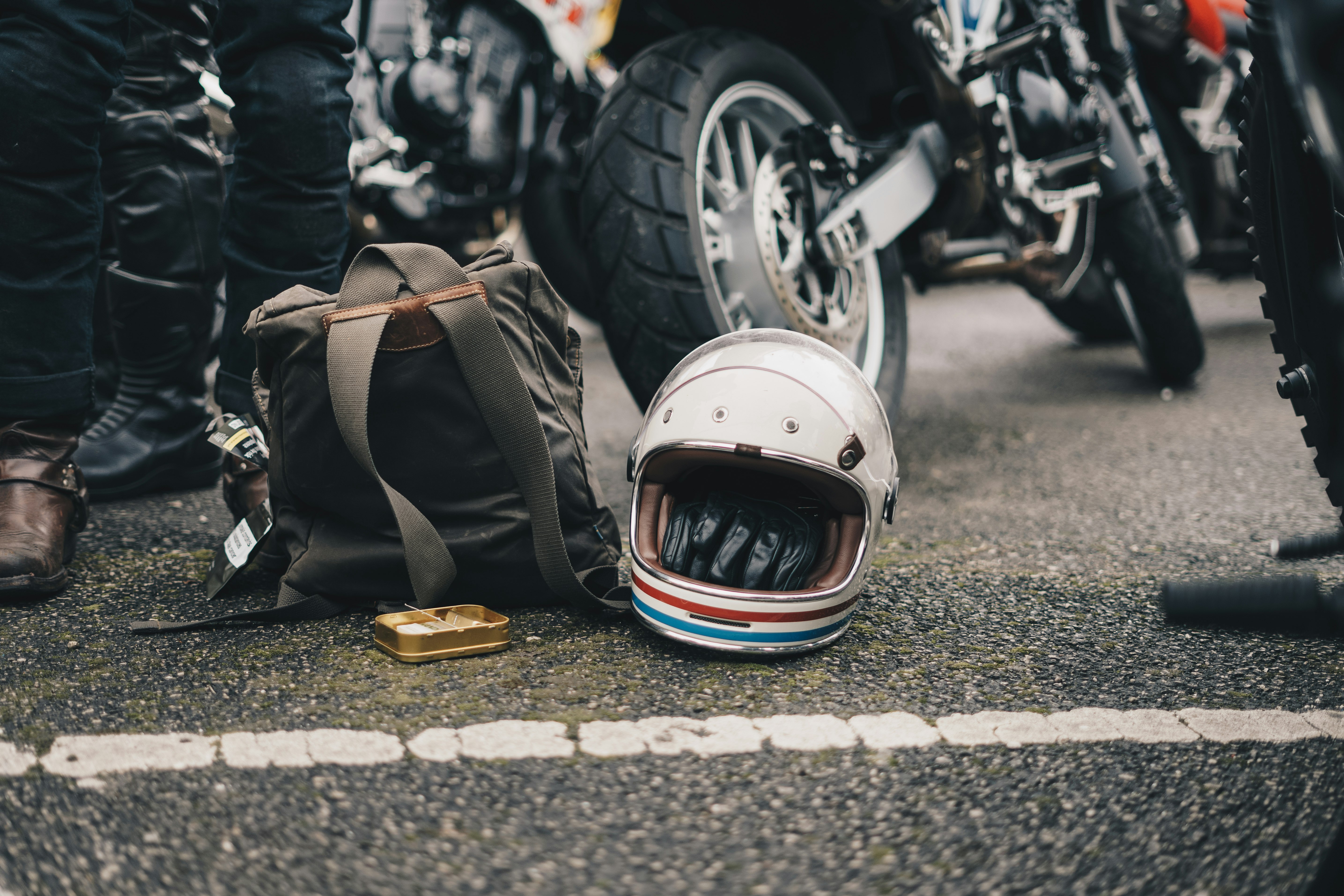 white helmet beside black backpack on road