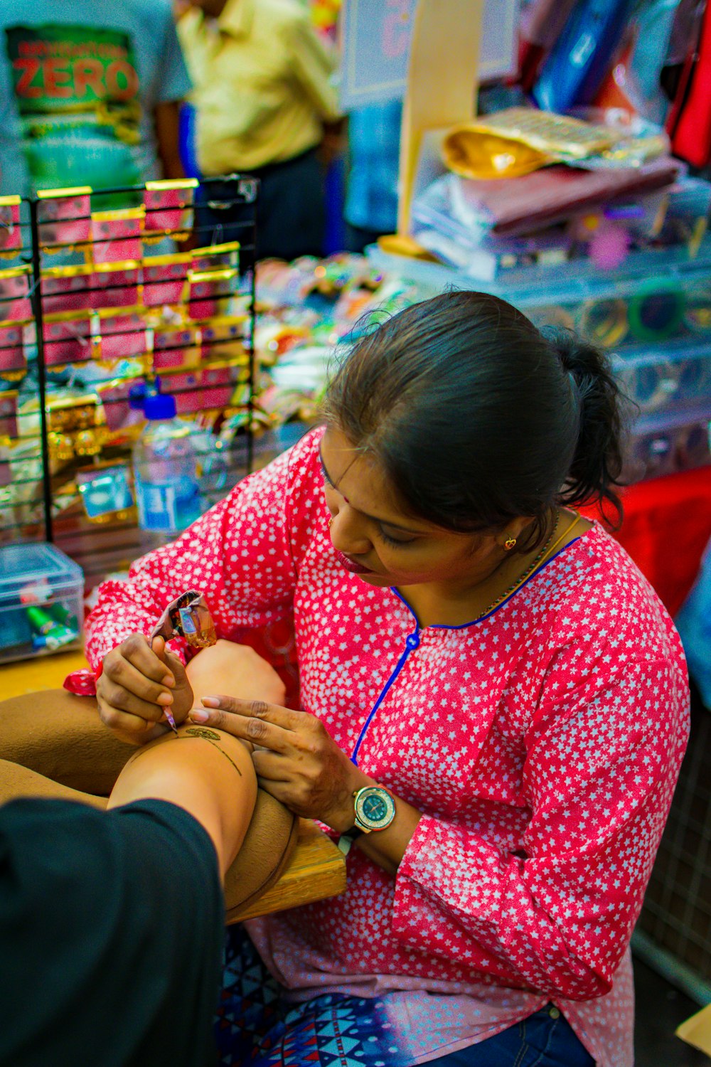 woman doing tattoo on person's arm