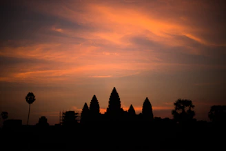 Aerial shot of Prambanan temple at sunset with vibrant orange sky.