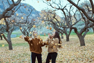 two smiling women in woods two teams background