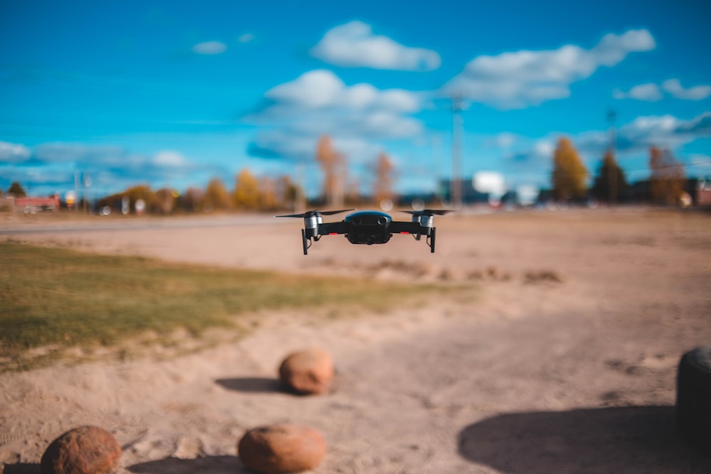 black quadcopter hovering outdoors