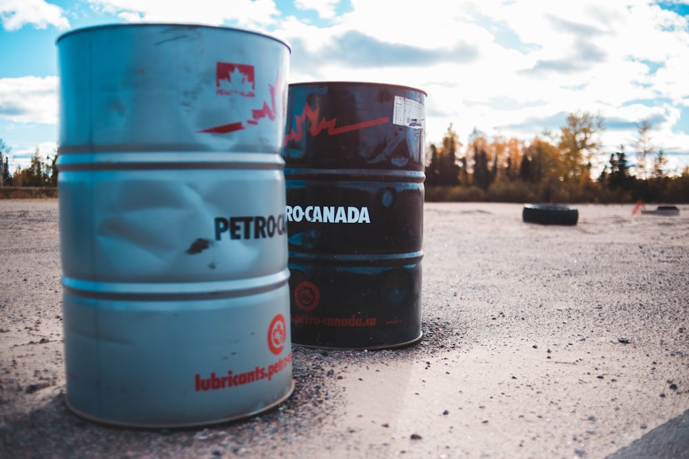 two gray and black metal barrels under cloudy sky\