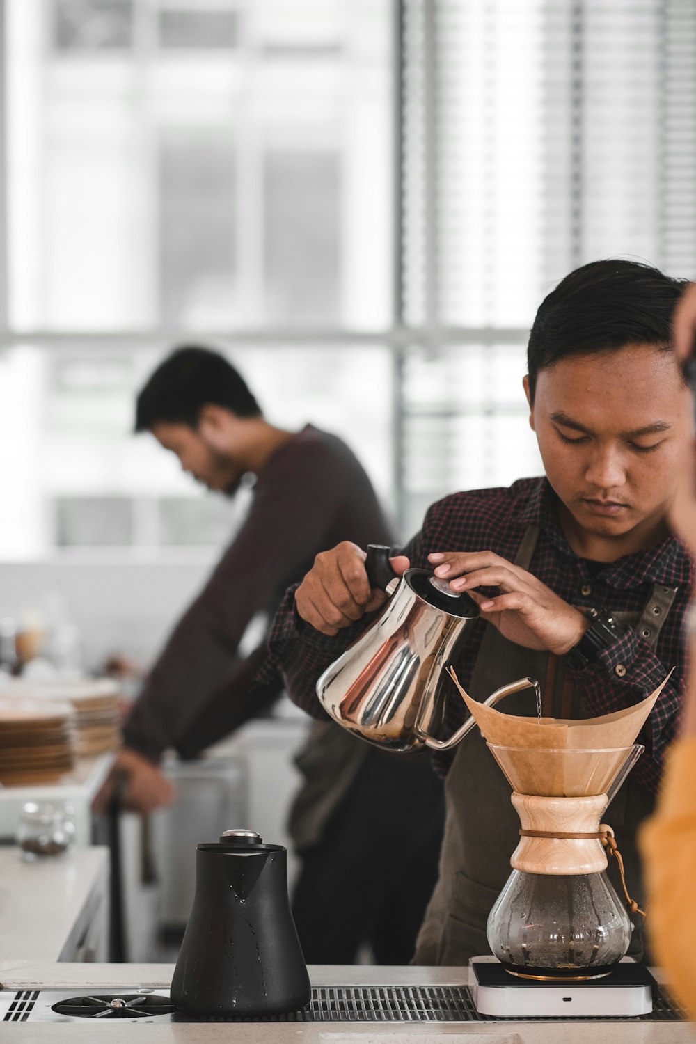 man pouring water in clear glass jar