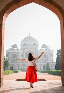 woman with hands on air facing mosque