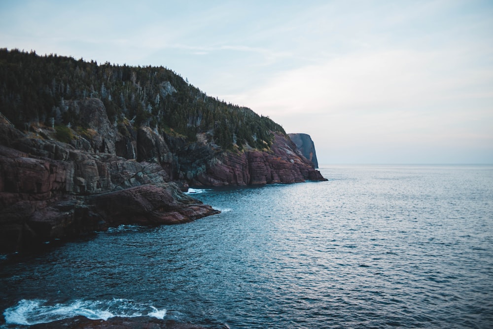 brown rocky mountain next to sea