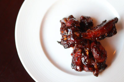 Golden, crispy Korean fried chicken wings glistening with spicy glaze, served with pickled radish on the side.