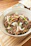 Close-up of a sizzling Mongolian beef dish garnished with fresh scallions and sesame seeds.