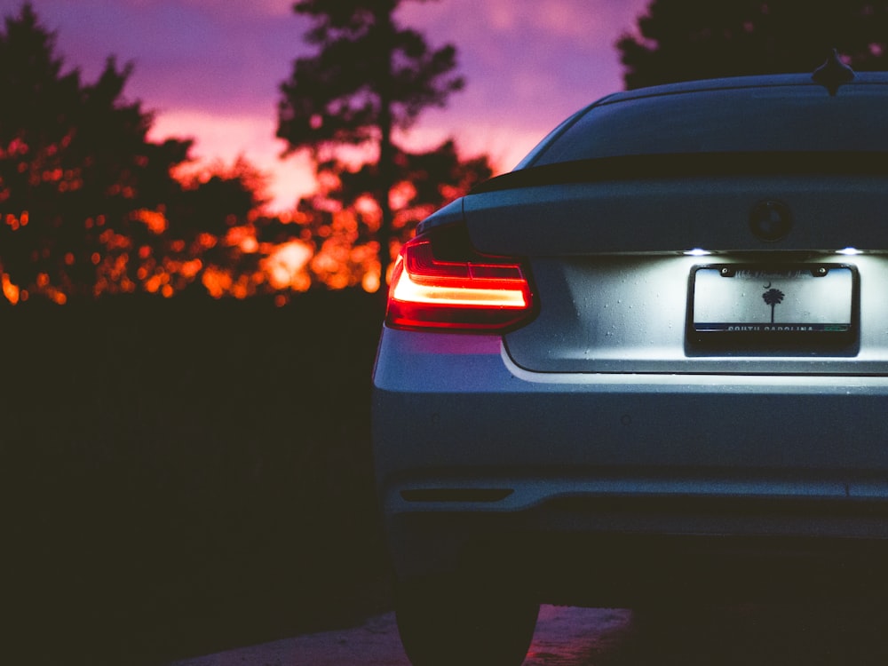 véhicule BMW gris sur la route à l’heure dorée