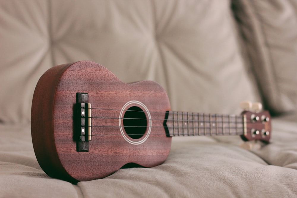 brown ukulele on couch